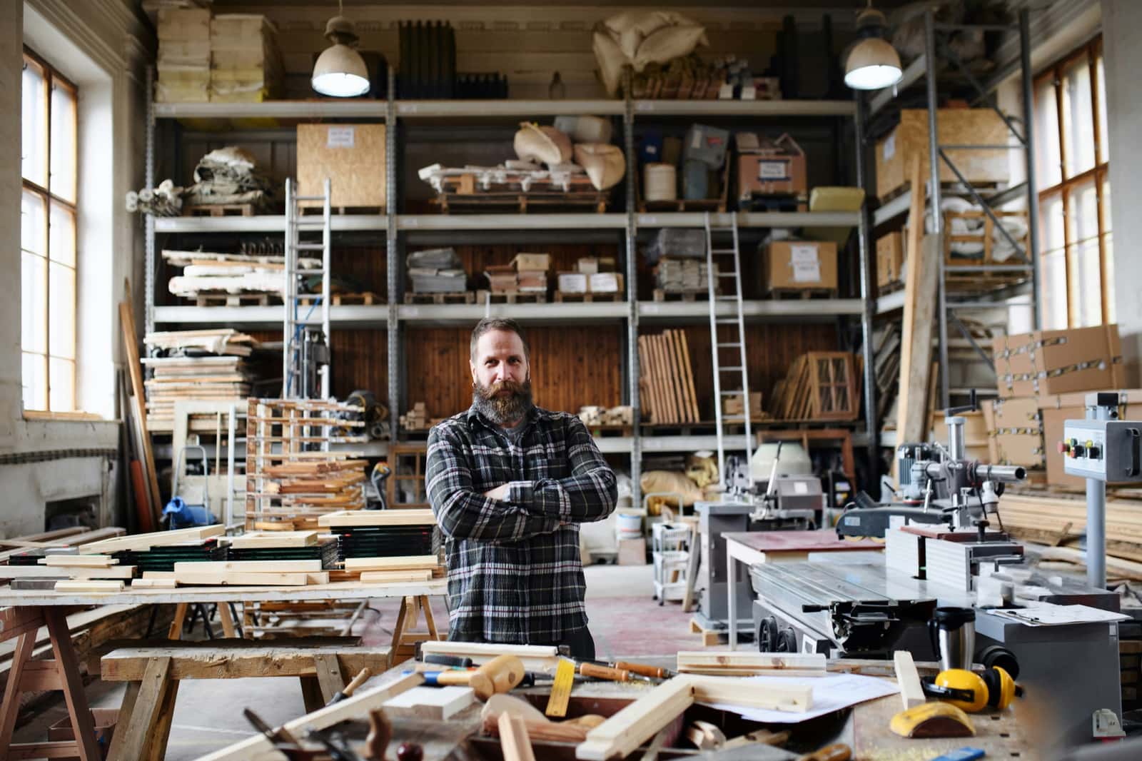 Established business owner standing in a workshop with tools and inventory