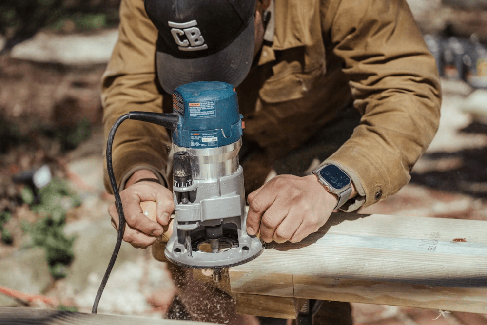 Contractor using a router on lumber at a job site